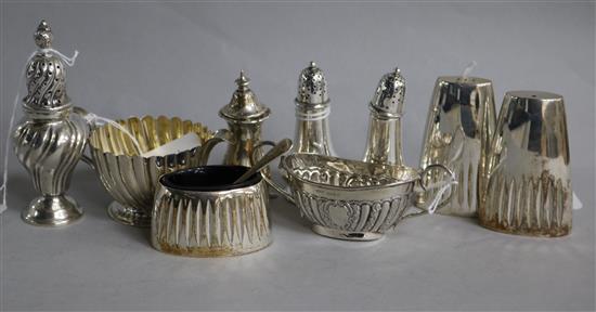 A small silver fluted cream jug and various silver condiments,